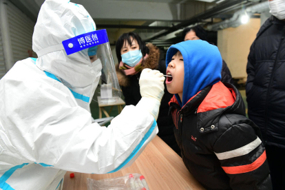 Un sanitario realiza una prueba PCR a un ciudadano en China.