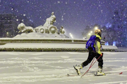 Varias personas caminan por la Puerta del Sol cubierta de nieve.
