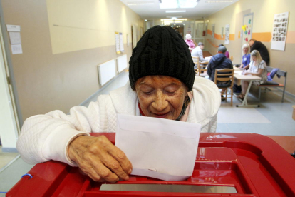 Una persona, ayer, depositando su voto en uno de los colegios electorales de la capital letona.
