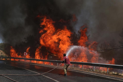 Un bomber combat l’incendi forestal al districte de Marmaris, a Mugla (Turquia).
