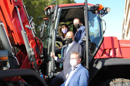 Jordà i Solsona en un dels tractors exposats, amb el director, Xavier Roure, i el president de la Diputació, Joan Talarn, a baix.
