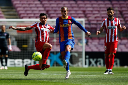 El jugador de l'Atlético de Madrid Stefan Savic intenta tallar l'avenç d'Antoine Griezmann, del FC Barcelona