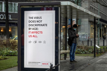 Un cartell adverteix del risc de contagi per a qualsevol edat, en una parada d’autobús a Berlin.