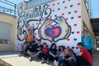 Els grafiters que van ajudar en l'elaboració del mural, amb el grup de joves de la Floresta, a la zona esportiva del poble.