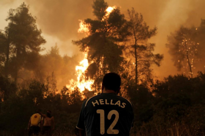 Un resident observa les flames que s’atansen, durant un incendi, al poble grec de Pefki.