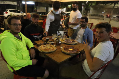 Un grupo de amigos cenando al aire libre en un restaurante del centro de Lleida ciudad.