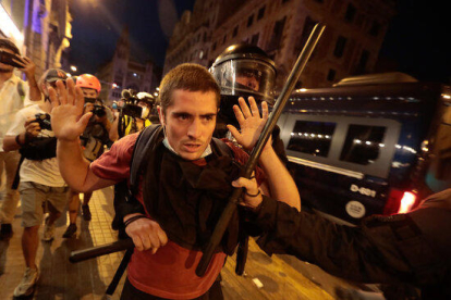 Un agente de los Mossos sujeta un manifestante en la Via Laietana.