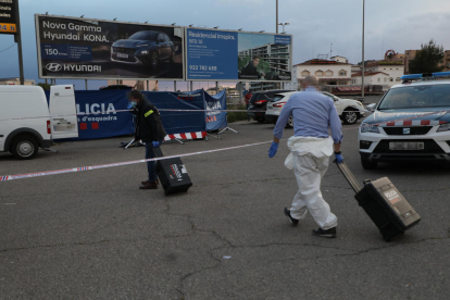 Agents d’investigació dels Mossos buscant proves a l’exterior del vehicle.