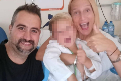 El niño y sus padres posan felices en la habitación del hospital