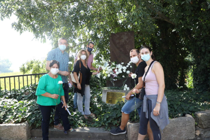 Veïns dipositant clavells blancs al monument de Butsènit que recorda la tragèdia.