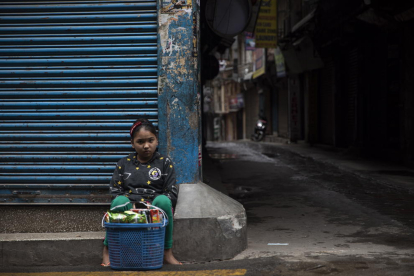 Una nena ven esnacs en un carrer a Katmandú.
