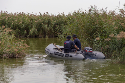 Agentes de los Mossos ayer al mediodía con una lancha en el pantano de Utxesa. 