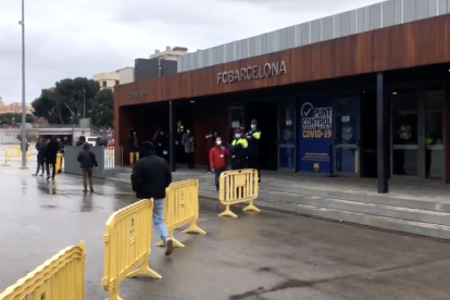 Varias personas esperan a las puertas del Camp Nou antes de entrar para votar este domingo en las elecciones catalanas