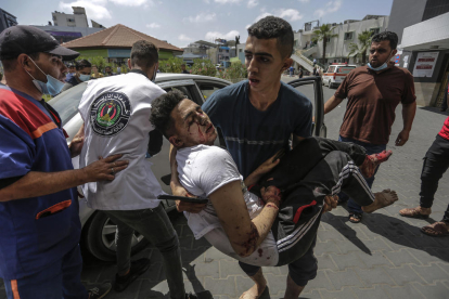 Un jove palestí trasllada un ferit pels bombardejos israelians a la ciutat de Gaza.