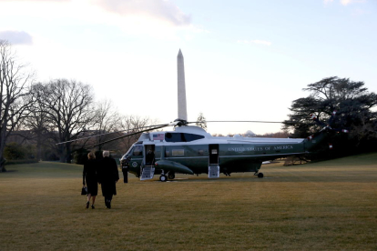 Els Trump, d'esquena, caminen cap a l'helicòpter amb el que han marxat de la Casa Blanca.