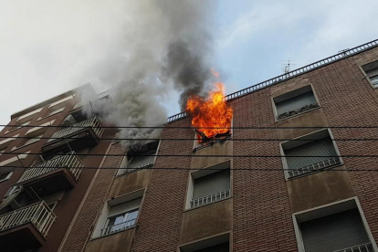 Imatge de les flames sortint per una de les finestres de l’habitatge afectat.