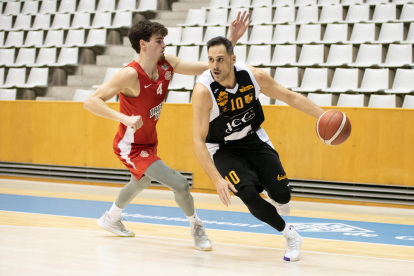 Mirza Bulic es disposa a llançar a cistella davant de Robert Cosialls, jugador del Bàsquet Girona.