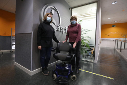 La socia de Aspid Pilar Gasol (derecha), entregando una silla de ruedas motorizada al banco de material solidario de la entidad. 