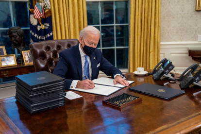 El president dels EUA, Joe Biden, firma ordres executives al Despatx Oval de la Casa Blanca.