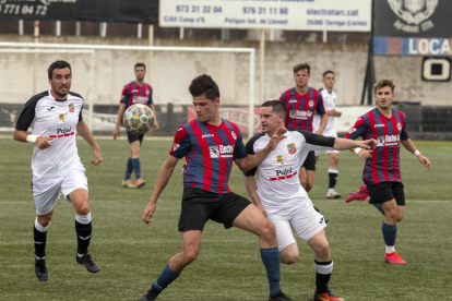 Florica, del Tàrrega, disputa la pilota davant d’un jugador del Borges mentre n’arriba un altre per ajudar-lo.