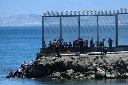Algunos de los inmigrantes llegados ayer a Ceuta tras atravesar el espigón de Benzú.
