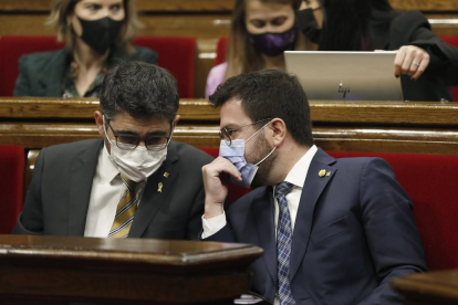 El president de la Generalitat, Pere Aragonès, parla amb el vicepresident del Govern i conseller de Polítiques Digitals, Jordi Puigneró, a l'inici de la sessió de control en el ple del Parlament.