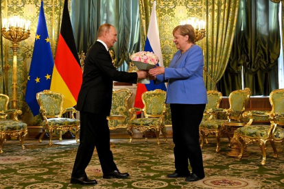 Putin entrega un ramo de flores a Merkel, ayer en Moscú.