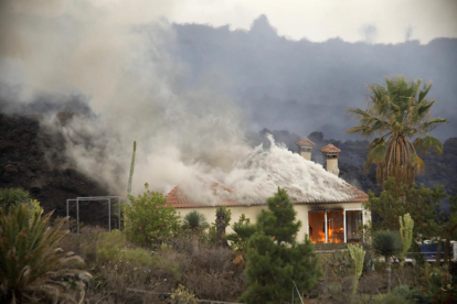 Una casa a Los Llanos sent devorada per les cues de lava que baixen des de Cumbre Vieja, que ja n’han arrasat més d’un centenar.