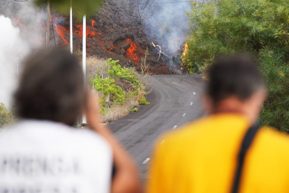 Dos personas observan la lava avanzando por la zona de Cabeza de Vaca en El Paso, La Palma, Santa Cruz de Tenerife, .