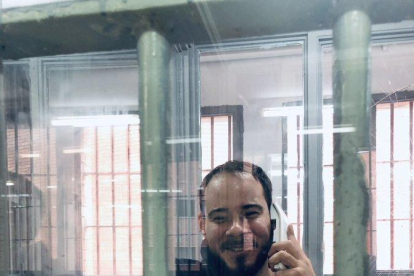 El raper Pablo Hasel parlant a través d'un telèfon en una de les cabines de visita de la presó de Ponent.