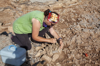 Ôscar Escala, d’Iltirta Arqueologia, mostra el nou túmul funerari (esquerra), i la restauradora Gemma Piqué neteja part d’un túmul descobert el 2015 (dreta).