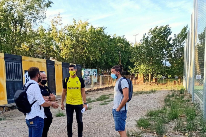 Amor, Vidal, García i un representant del club conversen sobre la zona que es vol pavimentar.