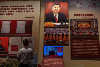 Un jove contempla un quadre de Xi Jinping en un museu.