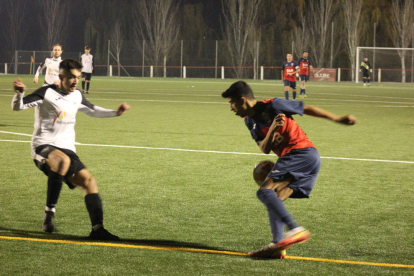 Un jugador de l’Ivars d’Urgell controla la pilota davant un defensor del Vallfogona de Balaguer.