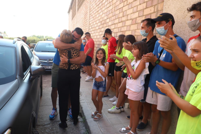 Saúl posa davant de la porta de casa amb els familiars, amics i veïns que es van reunir per donar-li la benvinguda.