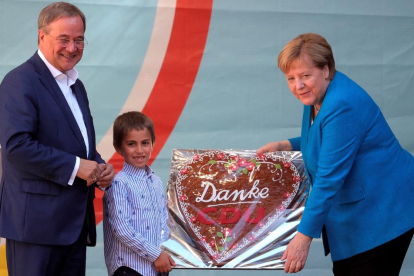 Merkel recibe un pastel de agradecimiento en un acto de campaña de Laschet ayer en Aachen.