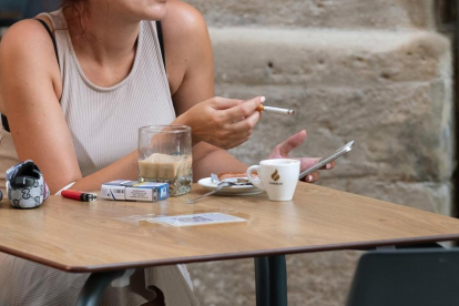 Una dona fuma un cigarro en una terrassa