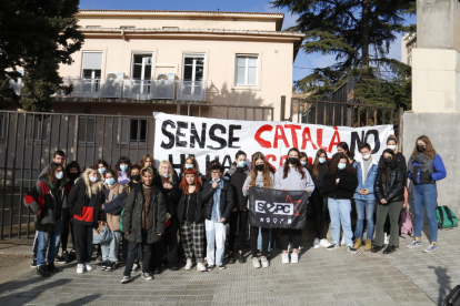 Estudiants de secundària davant del cartell que membres del SEPC han penjat davant l'Institut Màrius Torres de Lleida en defensa del català a les aules.