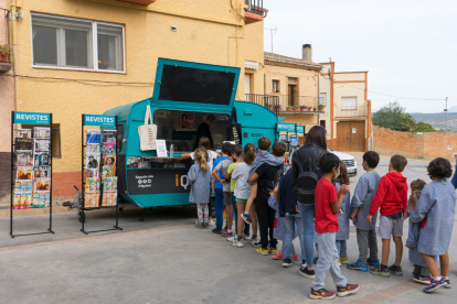 Escolars davant de la caravana de revistes i digitals en català, a la parada de les Avellanes.