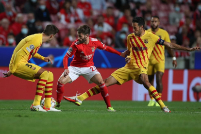 Piqué y Busquets presionan al benfiquista Rafa.