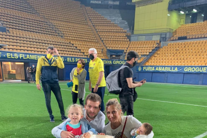 Adrià Adan ayer en el estadio de la Cerámica junto al trofeo con su mujer Jordina y sus hijos Mia y Max.