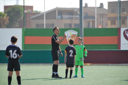 Xavier Estrada lanza la moneda para el sorteo de campo ayer en el Bordeta-Alpicat de benjamines ante su hijo Marc, de frente.