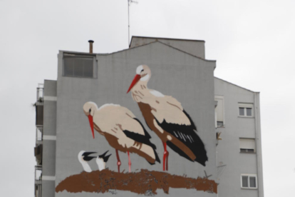 El artista Oriol Arumí posa ante la fachada que acoge el mural.