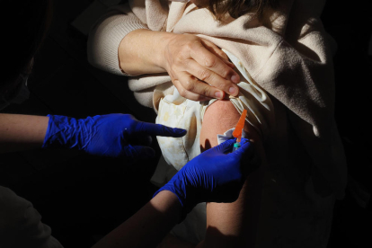Un treballador sanitari subministra la vacuna contra el Covid-19 a una persona.