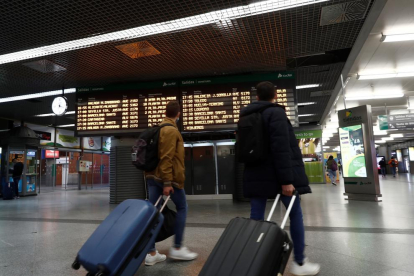 Dos viatgers en un vestíbul a l'estació d'Atocha de Madrid.