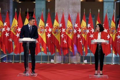 Sánchez y Ayuso escenificaron su apuesta por la colaboración ante 24 banderas de España y Madrid.