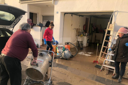 Veïns netegen la seua casa aquest divendres a Agramunt després de la riuada del Sió.