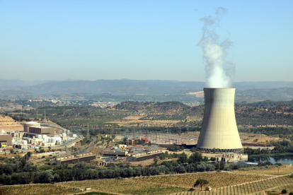 La central nuclear d'Ascó, a la Ribera d'Ebre, amb la xemeneia fumejant a la dreta i els dos reactors a l'esquerra.