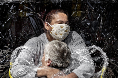 Una abraçada protegida amb plàstic per evitar contagis de covid-19, premi World Press Photo 2021