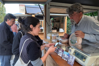 Una de les visitants de la fira utilitzant el codi QR per conèixer els diferents formatges.
